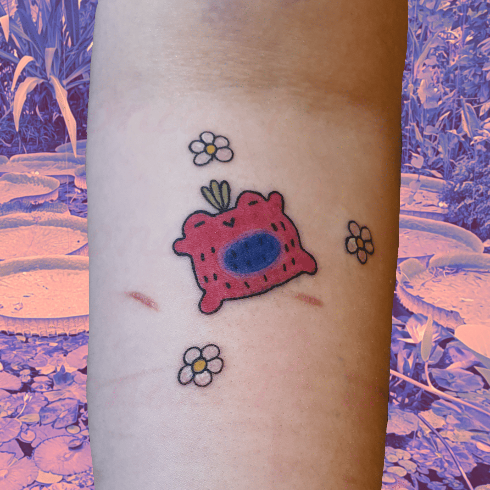 Tatouage en couleurs d'une grenouille fraise pour couvrir des cicatrices